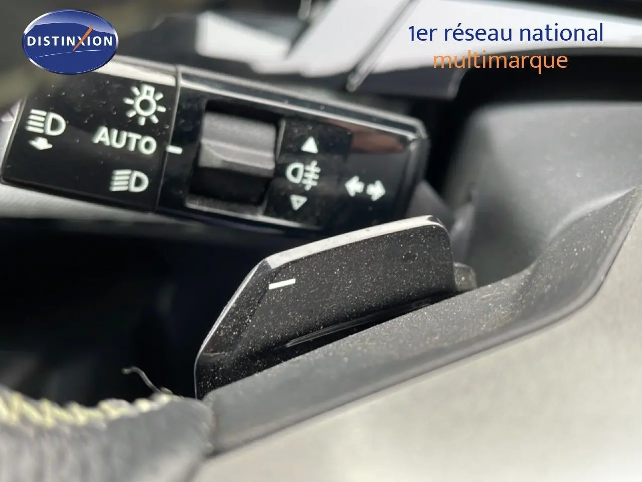Gros plan sur la commande des feux et le levier de vitesse au volant du Peugeot 3008 gris Artense 2025.