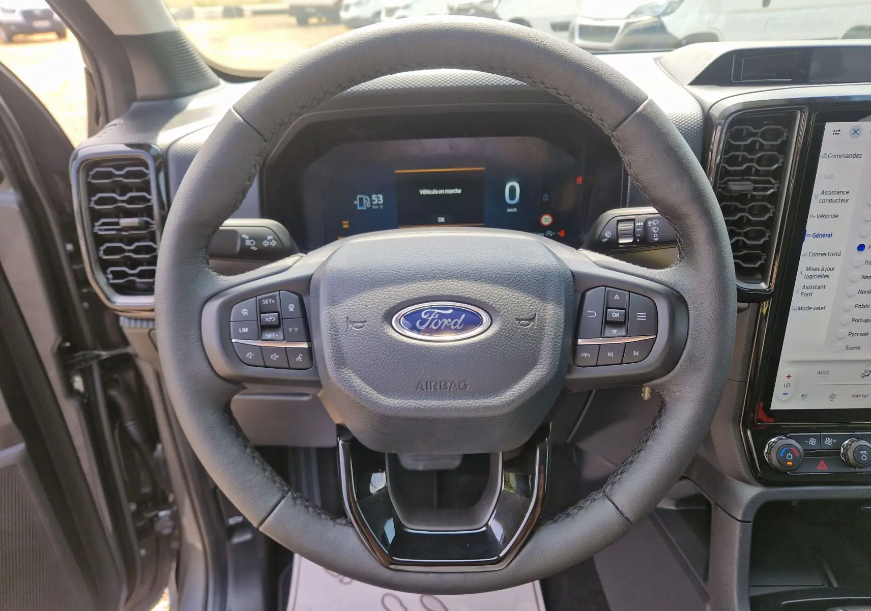 Vue rapprochée du volant noir du Ford Ranger Super Cabine 2026 avec tableau de bord numérique et écran tactile central.