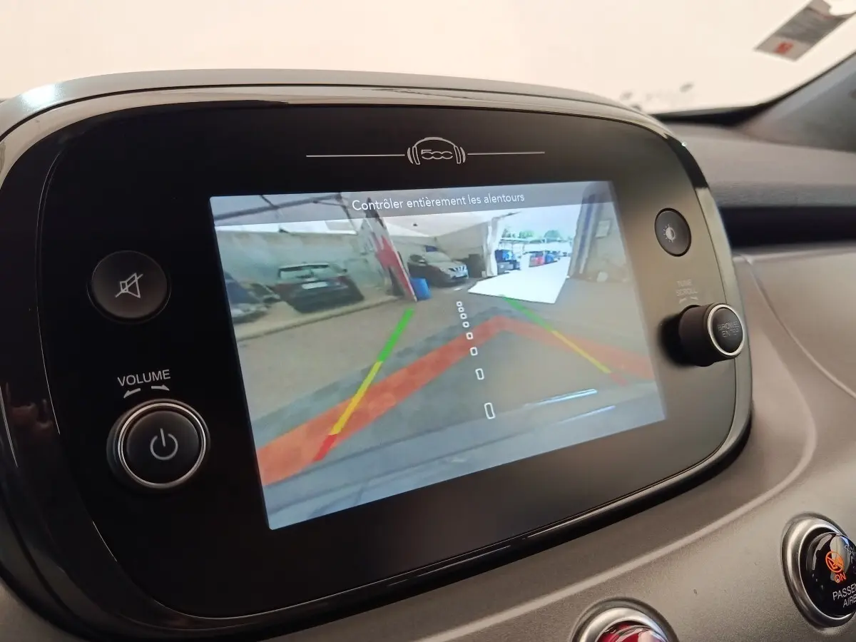 Écran tactile intérieur montrant la caméra de recul d'une Fiat 500X gris foncé, vue de face du tableau de bord.