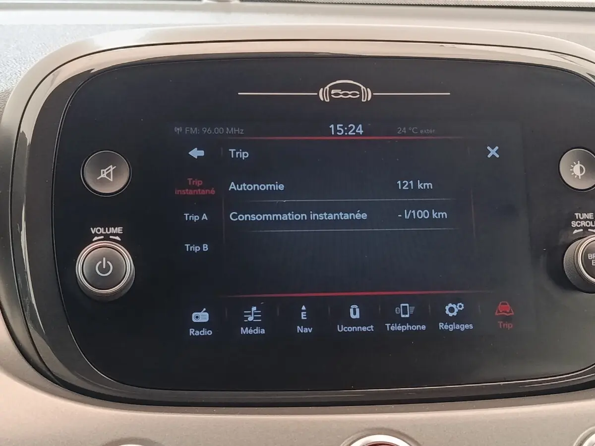 Écran tactile central de la Fiat 500X 2021 affichant l'autonomie et les options multimédia, entouré de commandes physiques.