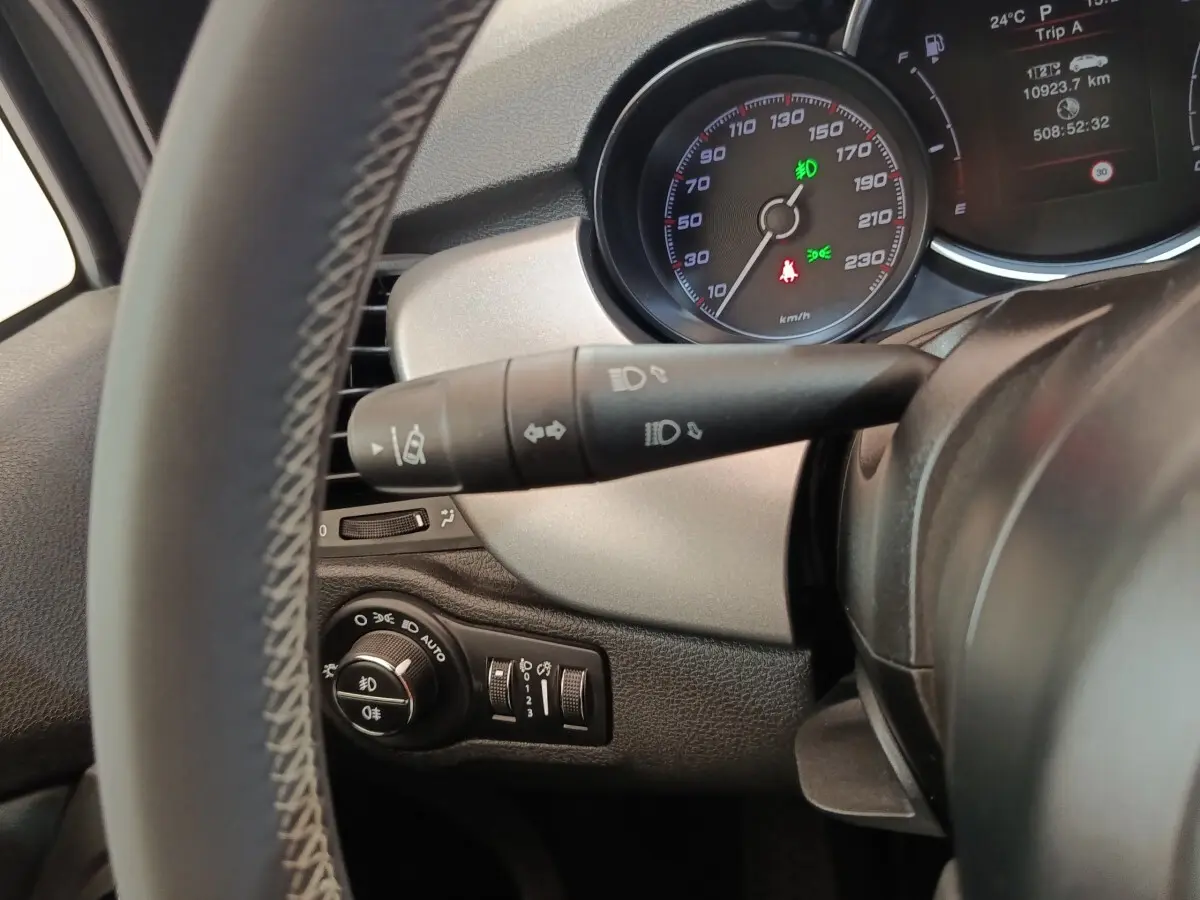 Vue rapprochée du tableau de bord côté gauche du Fiat 500X gris foncé, avec commandes d'éclairage et compteur visible.