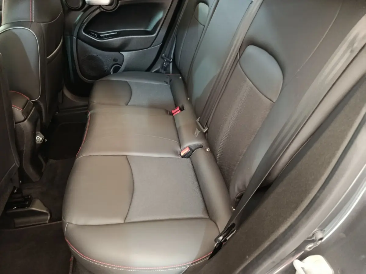 Banquette arrière en cuir noir avec surpiqûres rouges, vue côté droit de l'habitacle d'une FIAT 500X gris foncé.
