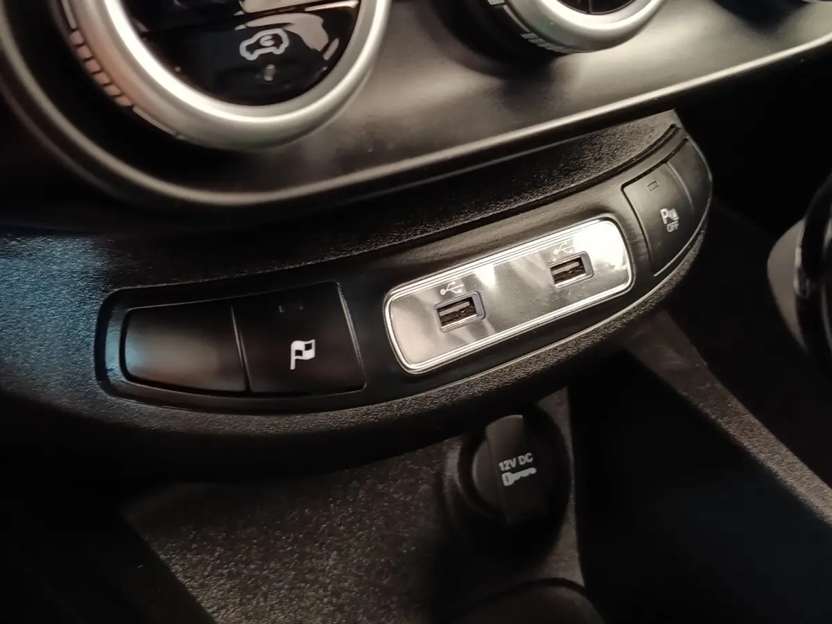 Gros plan sur les ports USB et boutons de commande du tableau de bord noir du Fiat 500X gris foncé 2021.