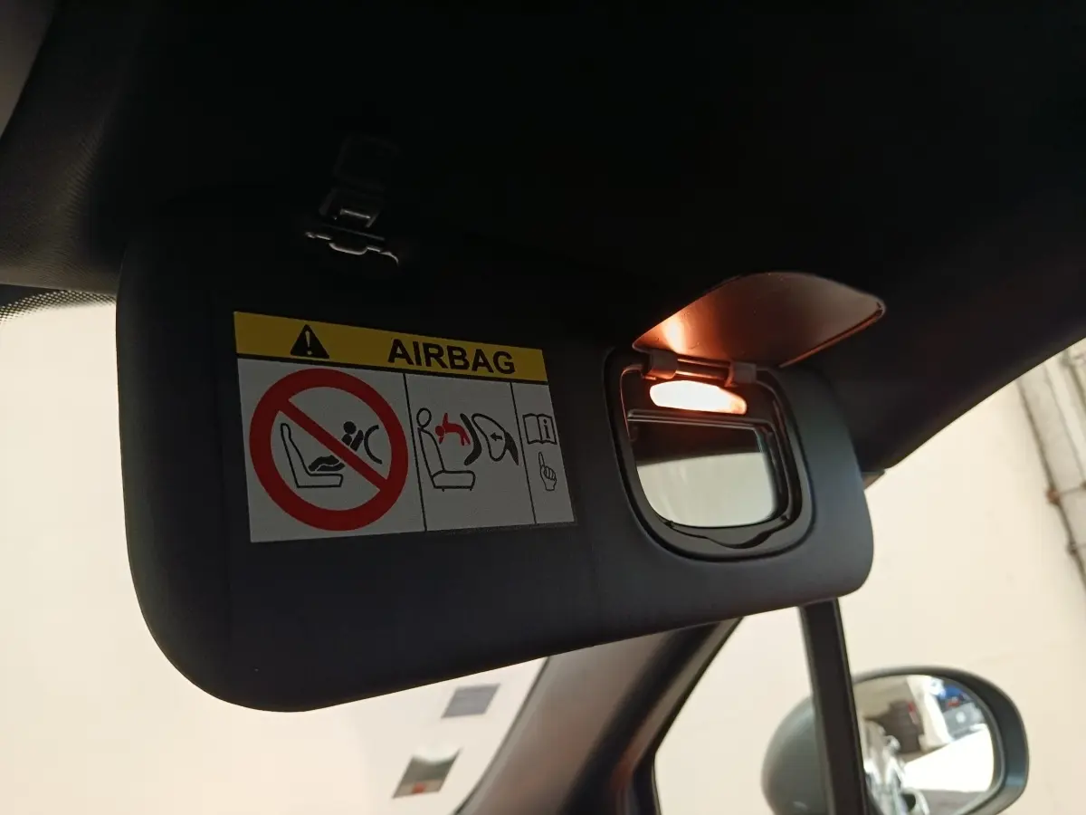 Détail du pare-soleil côté conducteur avec miroir éclairé dans l’habitacle sombre d’un Fiat 500X gris foncé.