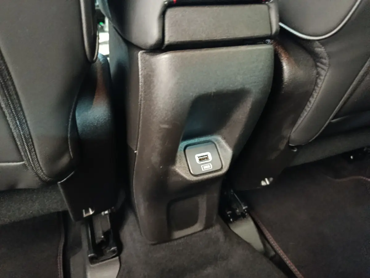 Prise USB arrière intégrée au bas de la console centrale, entre les sièges noirs du Fiat 500X gris foncé.
