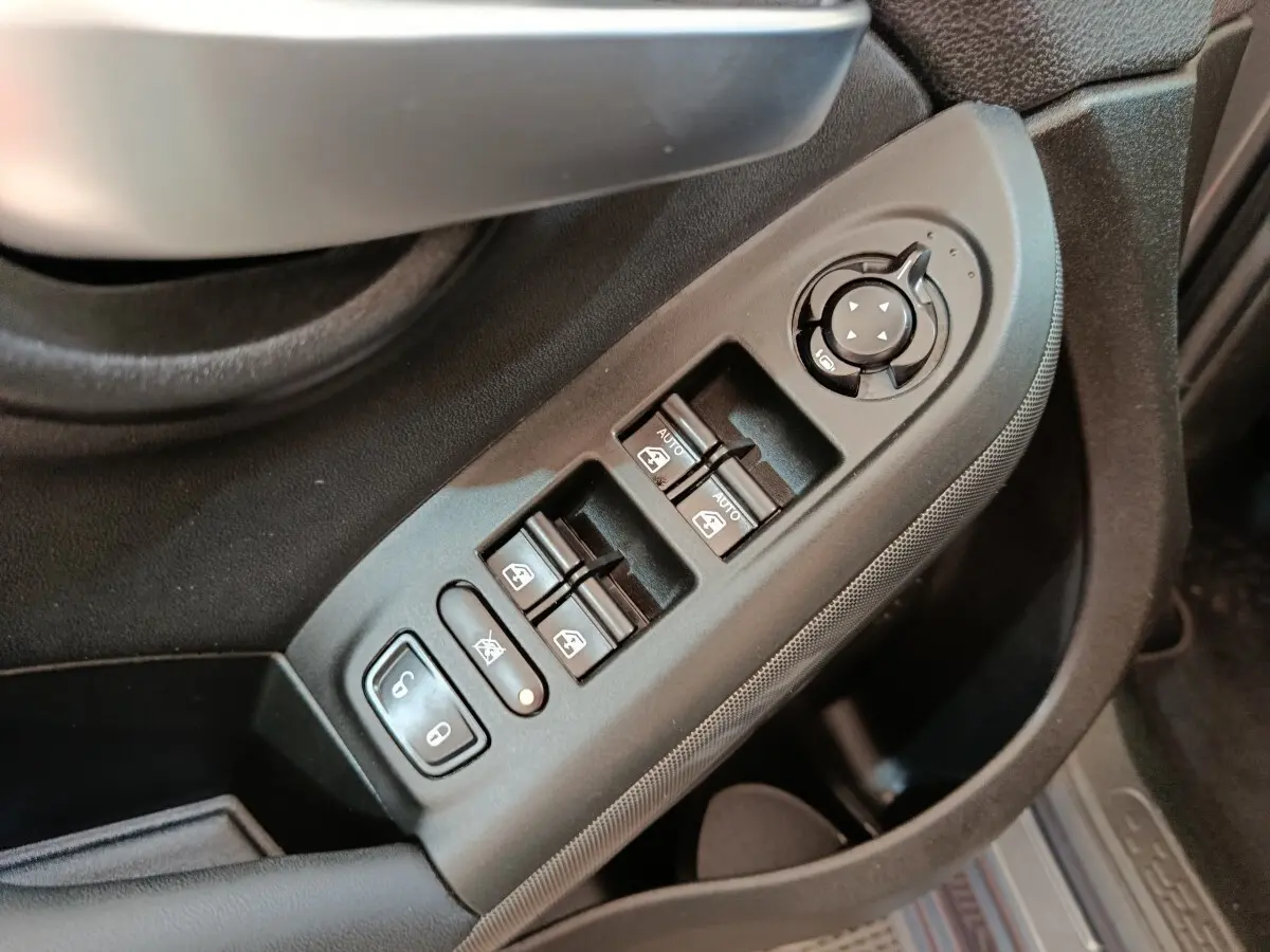 Commande des vitres électriques et réglage des rétroviseurs côté conducteur dans une Fiat 500X gris foncé, vue intérieure rapprochée.