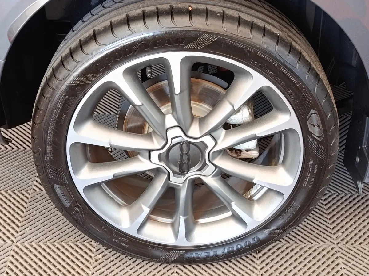 Gros plan sur la jante alliage grise et le pneu Goodyear d’un FIAT 500X gris foncé, vue côté roue avant.