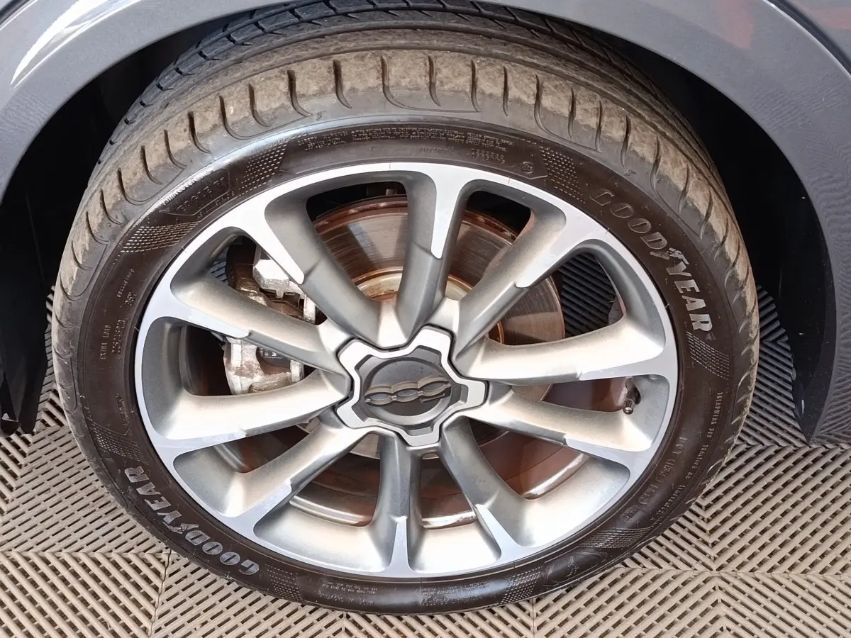 Gros plan sur la roue avant gauche gris foncé d’un FIAT 500X avec jante alliage et pneu Goodyear.