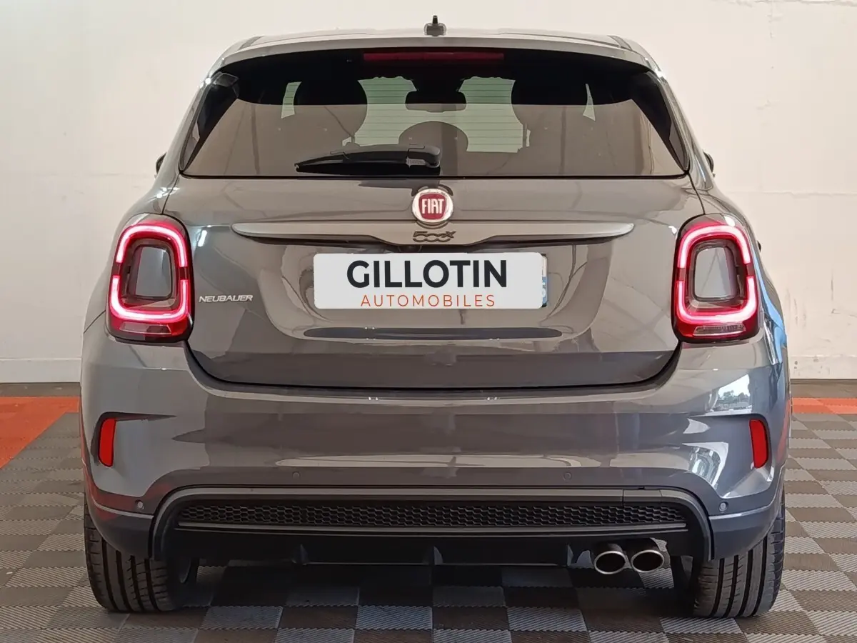 Vue arrière d'une FIAT 500X gris foncé avec feux LED allumés et double sortie d'échappement à droite.