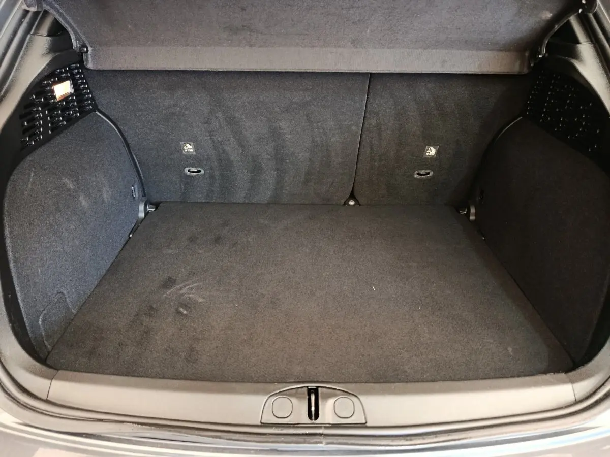 Coffre ouvert de la FIAT 500X gris foncé, vue intérieure montrant la surface plane et les parois en tissu noir.