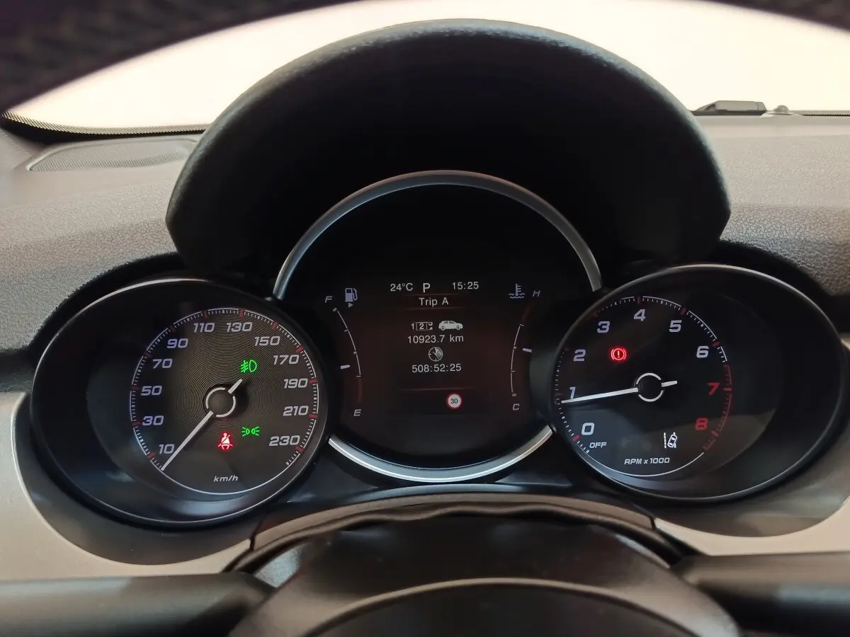 Vue rapprochée du tableau de bord de la Fiat 500X 2021, affichage digital central et compteurs analogiques noirs.