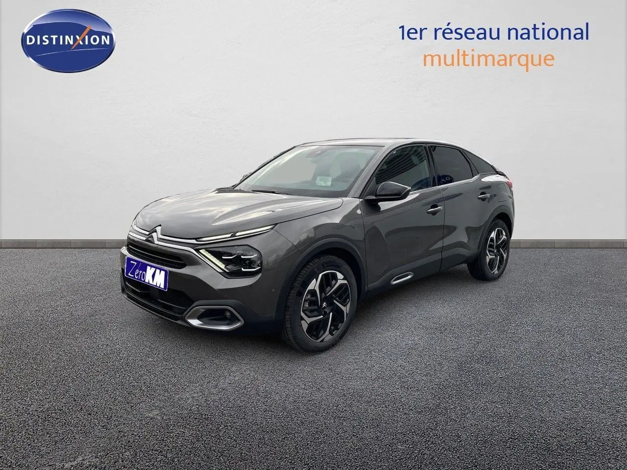 Citroën C4 gris platinium métal en 3/4 avant droit, mettant en valeur ses lignes modernes et ses jantes bicolores.