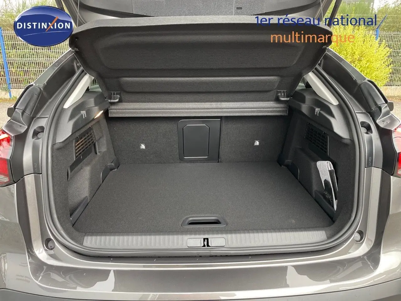 Coffre ouvert vu de l'arrière d'une Citroën C4 gris platinium métal, montrant un espace de chargement propre et spacieux.