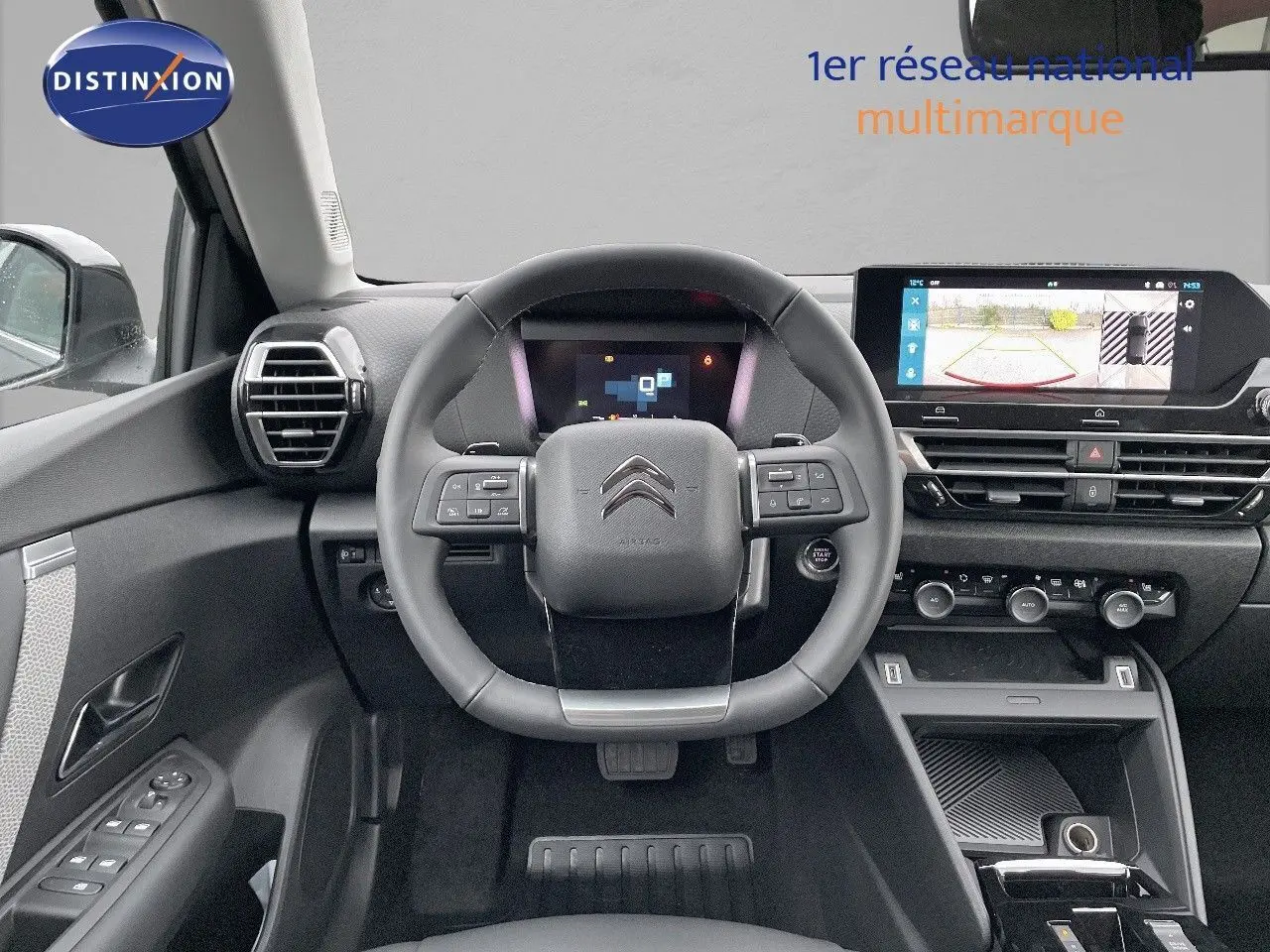 Intérieur de la Citroën C4 2024 en gris platinium, vue frontale du volant et tableau de bord avec écran tactile et caméra de recul.
