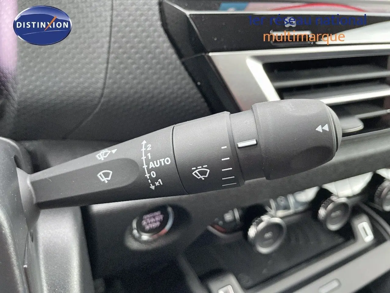 Gros plan sur la commande d'essuie-glace à gauche du volant dans l'habitacle d'une Citroën C4 gris platinium 2024.