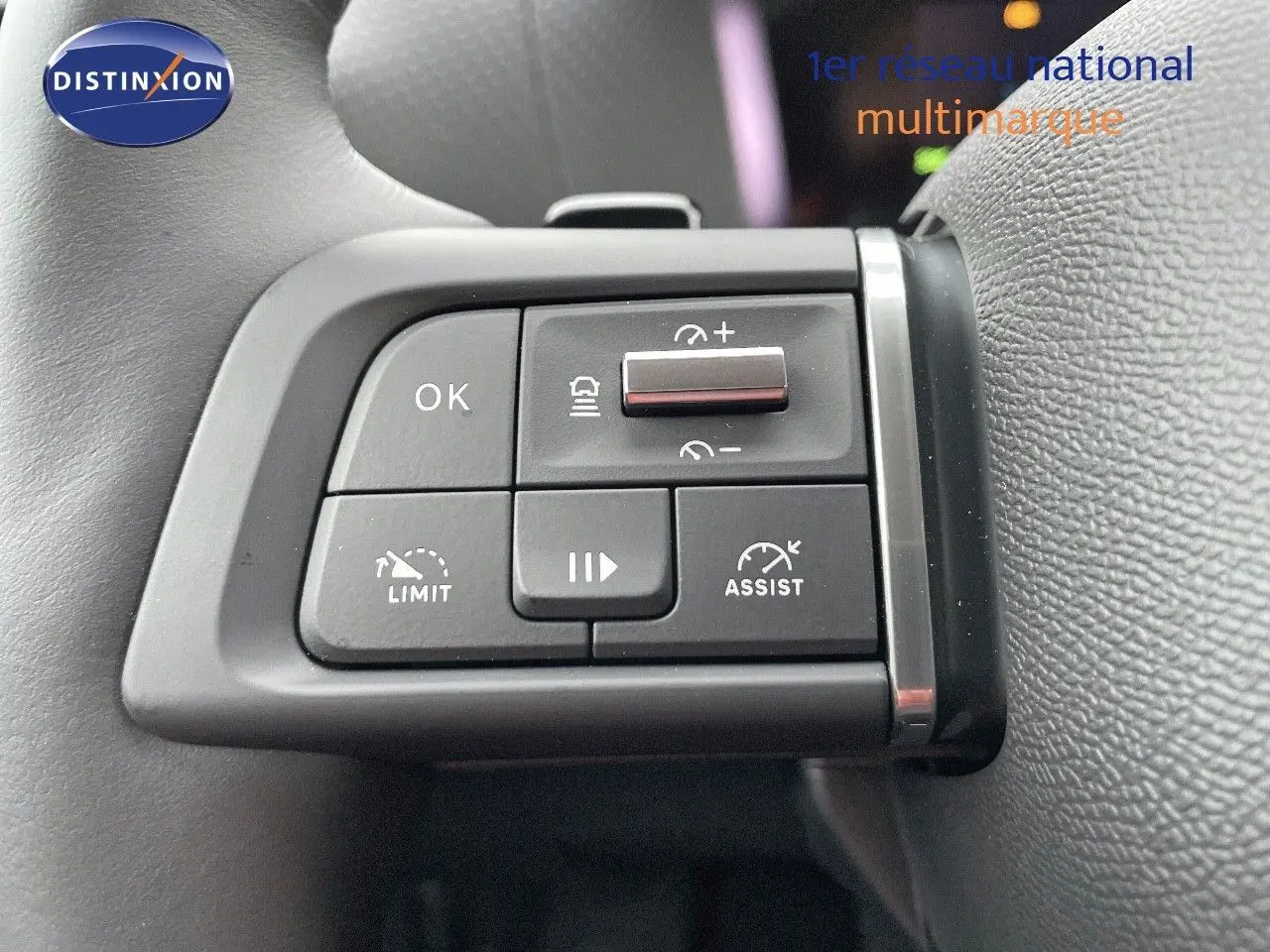 Gros plan sur les commandes au volant gauche de la Citroën C4 2024 gris platinium, avec boutons d'assistance et limiteur.