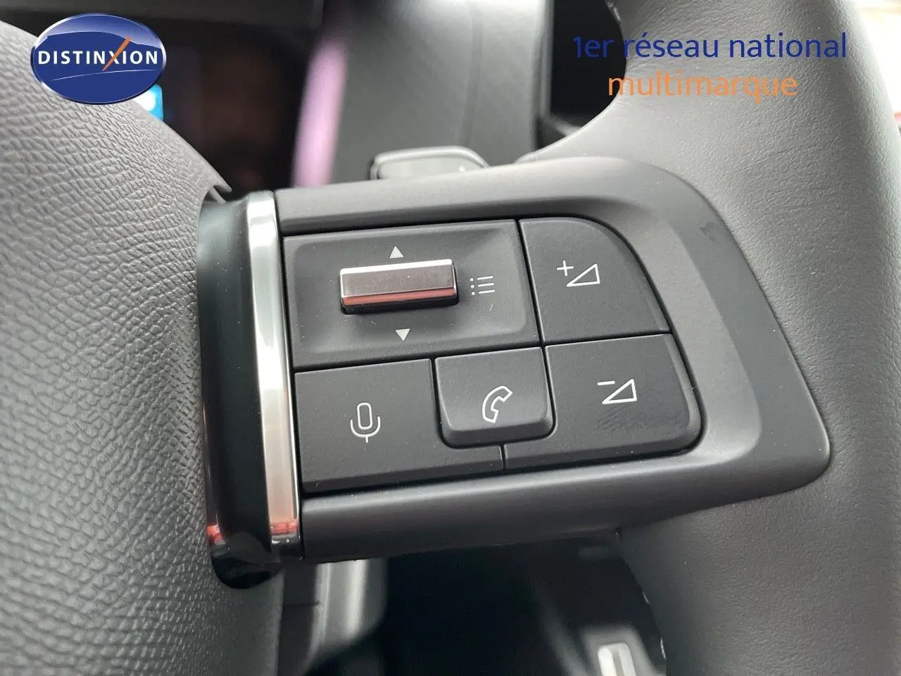 Gros plan sur les commandes au volant du côté gauche du Citroën C4 gris platinium 2024, boutons de volume et appel.