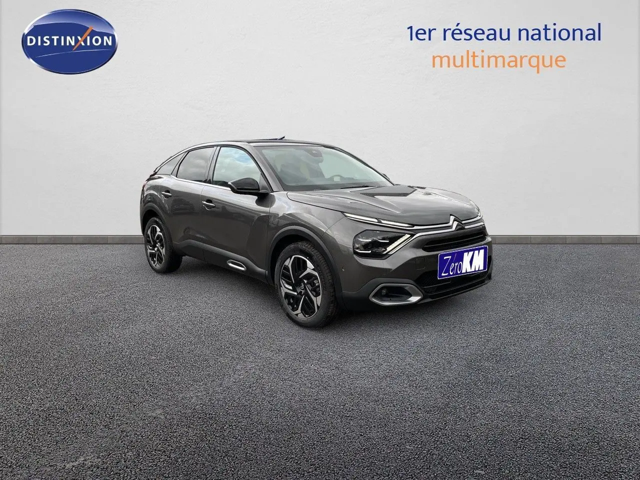 Citroën C4 gris platinium métal vue 3/4 avant droit, mettant en valeur ses lignes modernes et ses jantes bicolores.