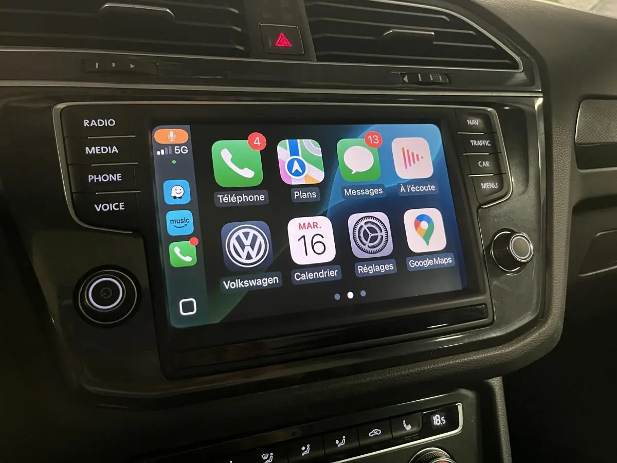 Écran tactile central du Volkswagen Tiguan 2017 affichant l'interface Apple CarPlay avec commandes autour en finition noire.