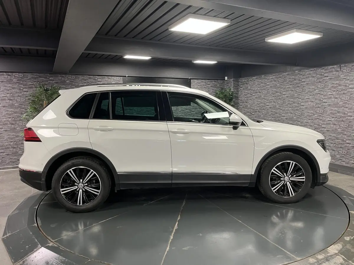 Profil droit du Volkswagen Tiguan blanc 2017 avec jantes alliage noires et garnitures basses noires.