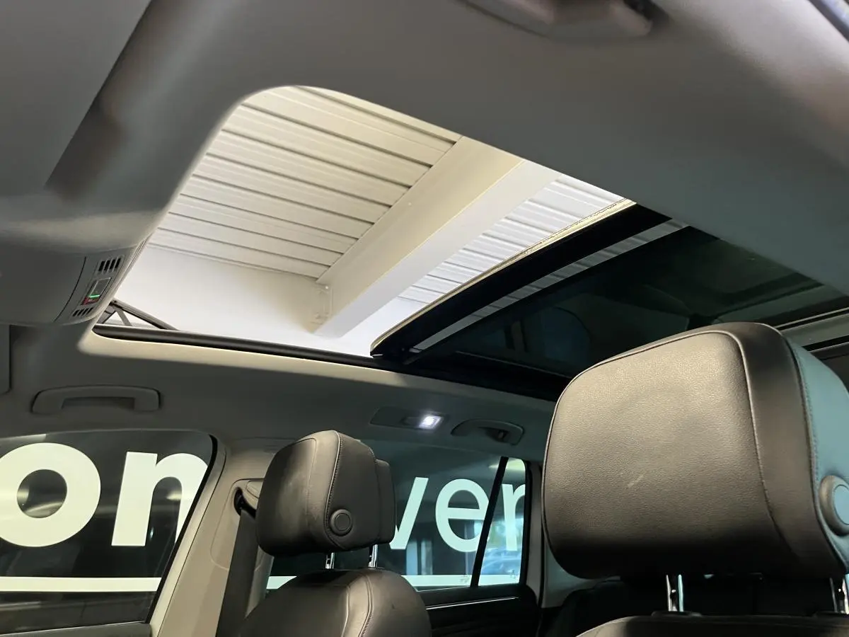 Vue intérieure du Volkswagen Tiguan 2017 montrant les appuis-tête avant en cuir noir et le toit ouvrant panoramique.