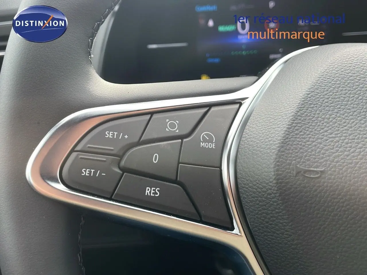 Gros plan sur les commandes au volant du Renault Captur E-Tech gris cassiopée, mettant en valeur les boutons de régulateur de vitesse.