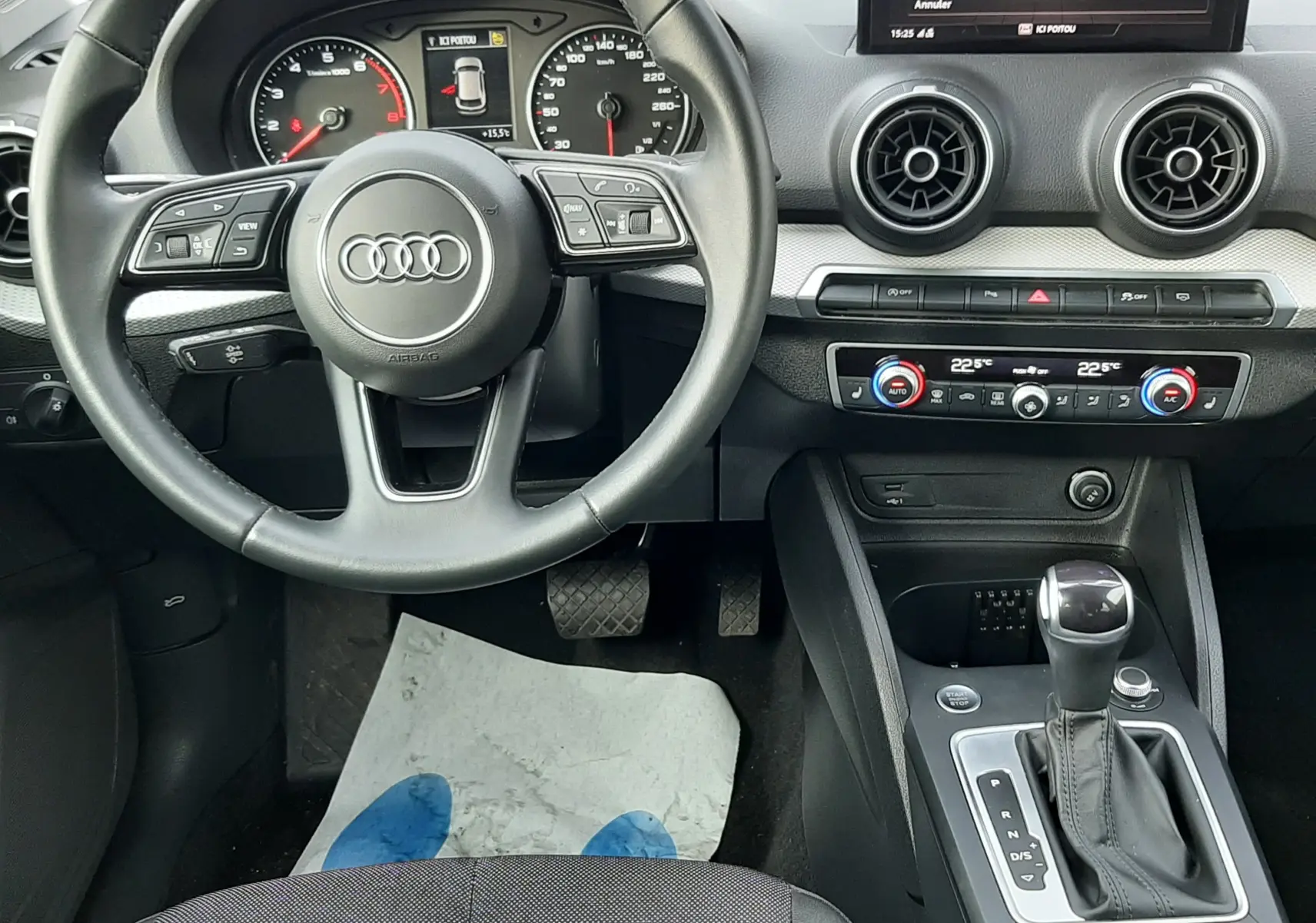 Vue intérieure de l'Audi Q2 35 TFSI 2023 montrant le volant, tableau de bord et console centrale avec boîte auto.