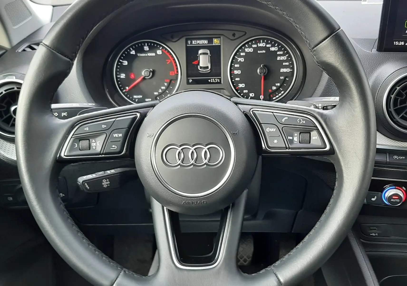 Vue frontale du volant noir de l'Audi Q2 35 TFSI 2023 avec tableau de bord numérique et commandes intégrées.