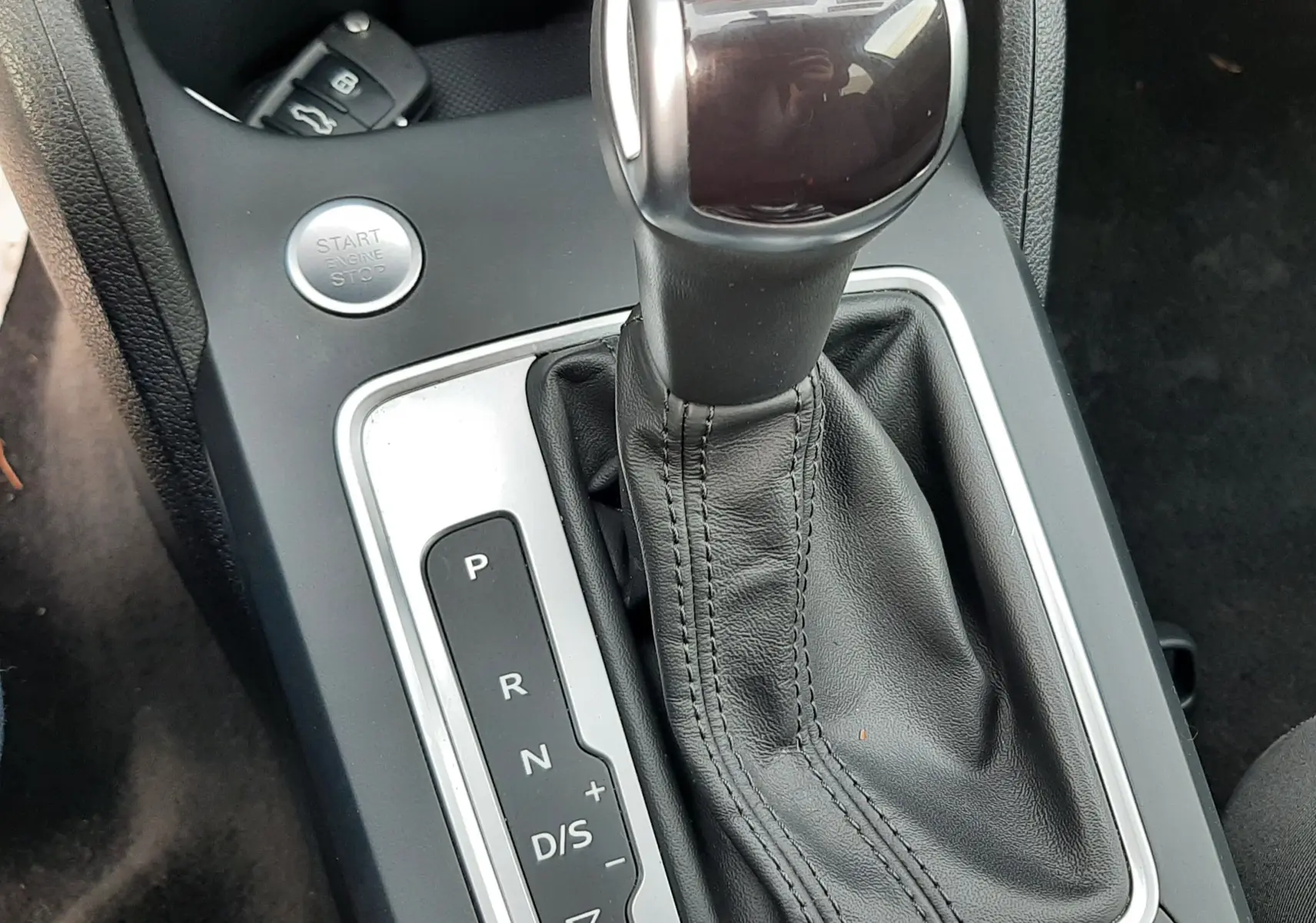 Le levier de vitesse automatique noir et argenté de l'Audi Q2 35 TFSI S-Line, vu en gros plan intérieur.