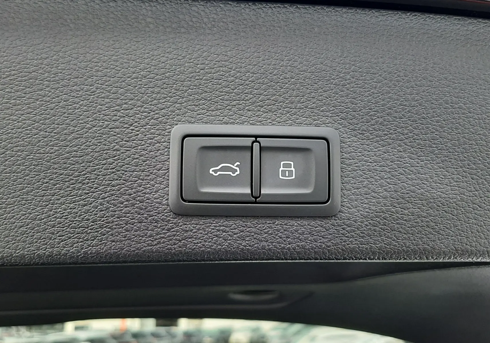 Gros plan sur les boutons d'ouverture et de verrouillage du hayon intérieur d'un Audi Q2 noir mito metal 2023.