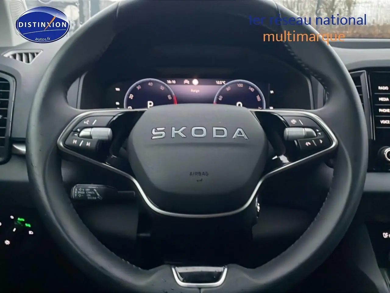 Vue rapprochée du volant cuir multifonction SKODA KAROQ 2025 avec tableau de bord numérique en arrière-plan.