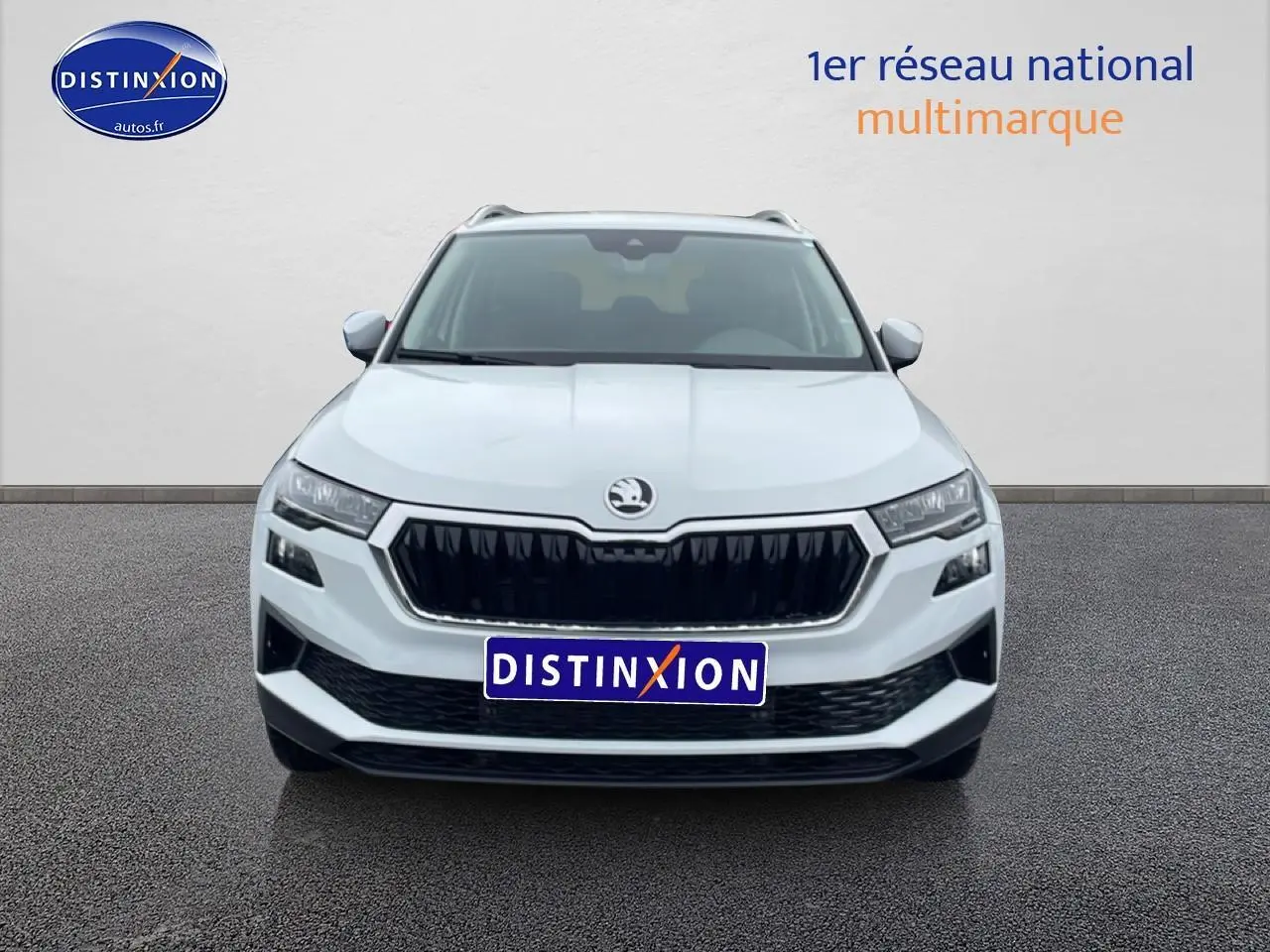 Vue frontale d'un Skoda Karoq blanc glacial avec calandre noire et phares LED distinctifs.