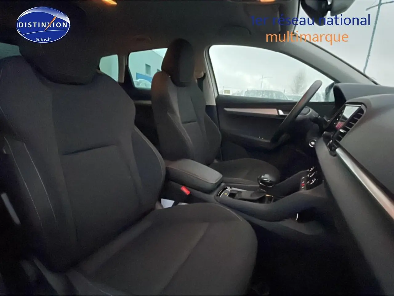 Intérieur noir du Skoda Karoq 1.5 TSI 2025 vu côté conducteur, avec console centrale et volant multifonction.