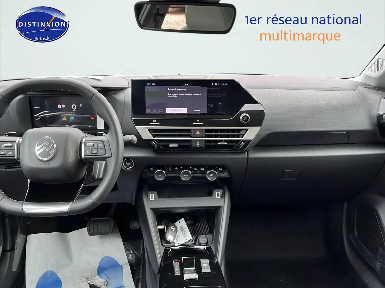 Intérieur moderne du Citroën C4 2025, vue frontale du tableau de bord avec écran tactile et volant cuir noir.