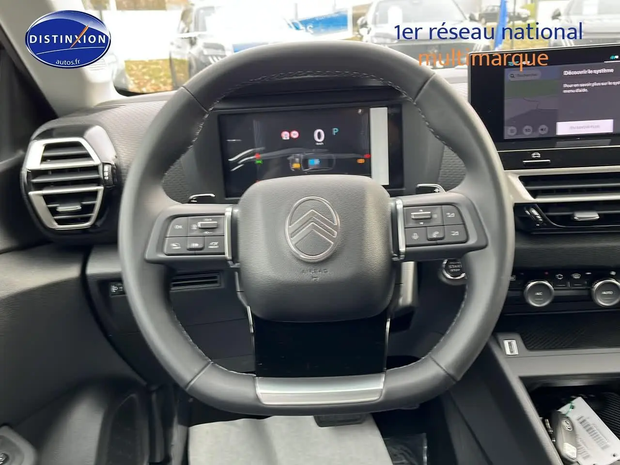 Vue centrée sur le volant cuir du Citroën C4 1.2 hybride 2025 avec tableau de bord numérique et écran tactile.
