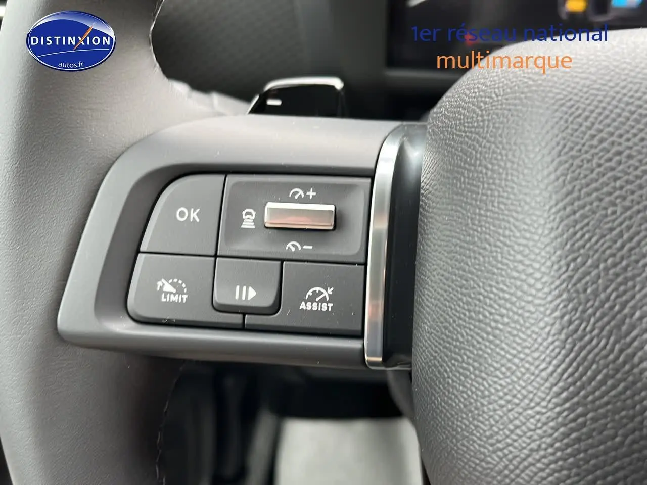 Gros plan sur les commandes de régulateur de vitesse au volant cuir d'une Citroën C4 noire métal 2025.