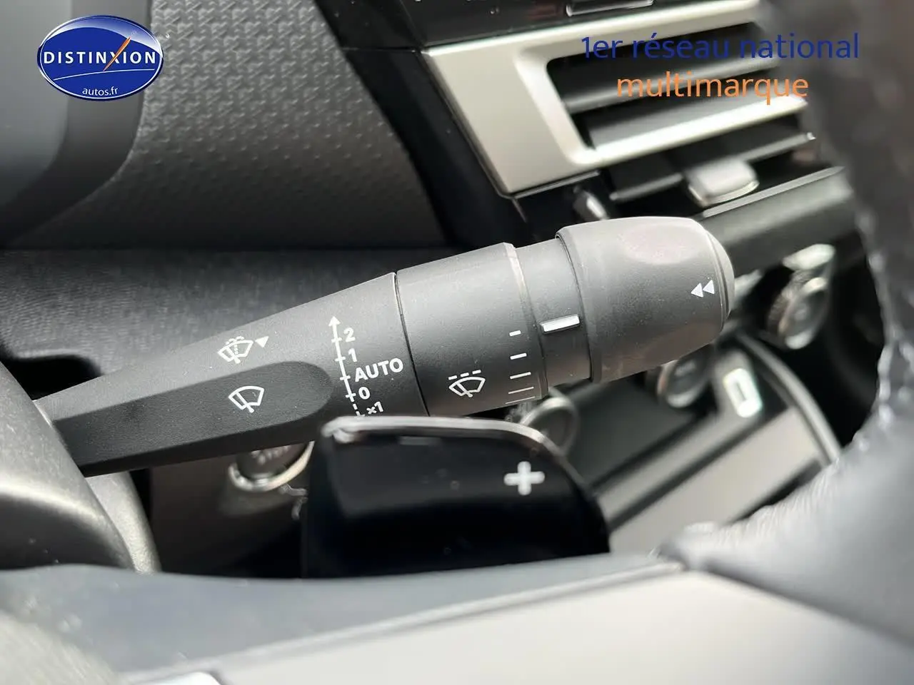 Gros plan sur la commande d'essuie-glace et palettes au volant d'une Citroën C4 noire métal 2025.