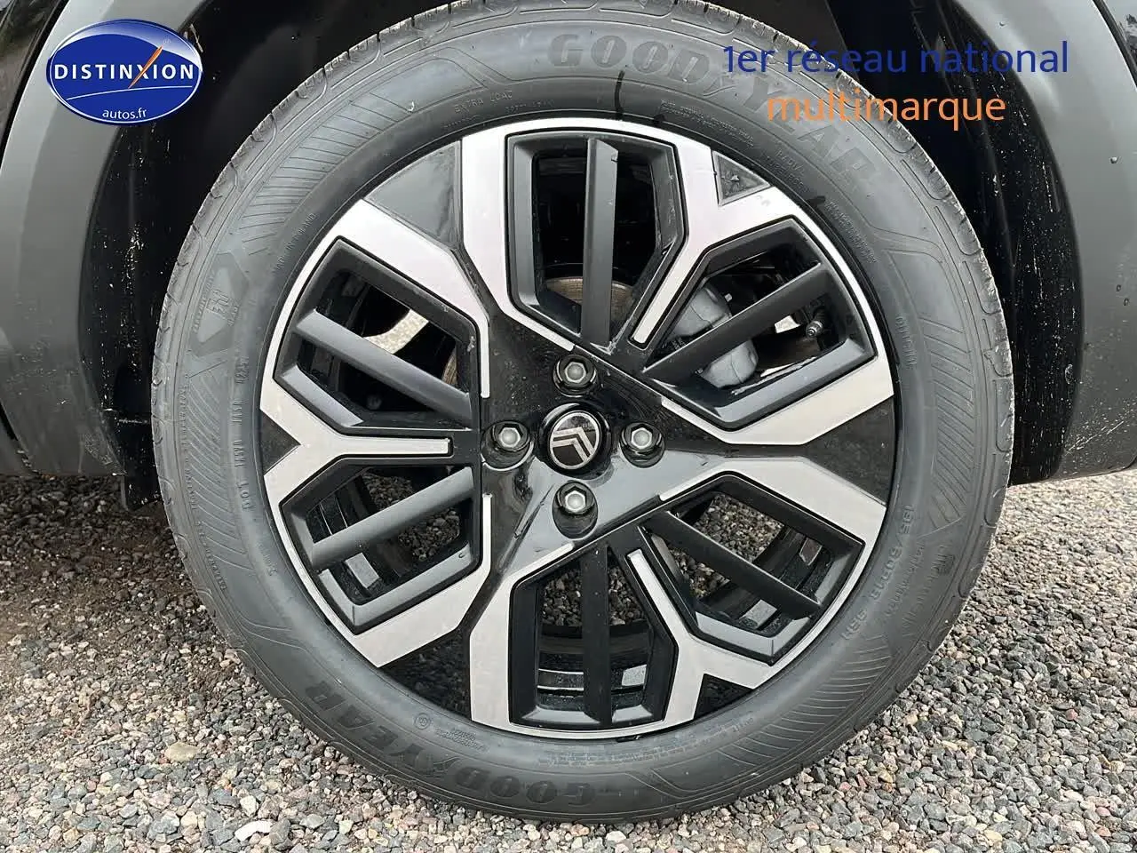 Vue arrière d'une Citroën C4 noire métal avec jantes alliage 18 pouces et rétroviseurs noirs brillants sur sol gravillonné.