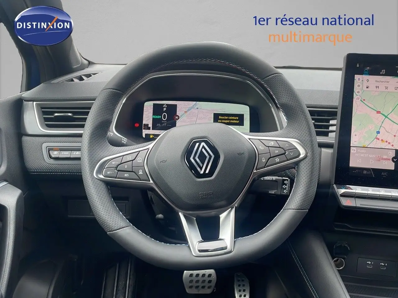 Vue intérieure centrée sur le volant du Renault Captur E-Tech hybride 2025 avec tableau de bord numérique et écran tactile.