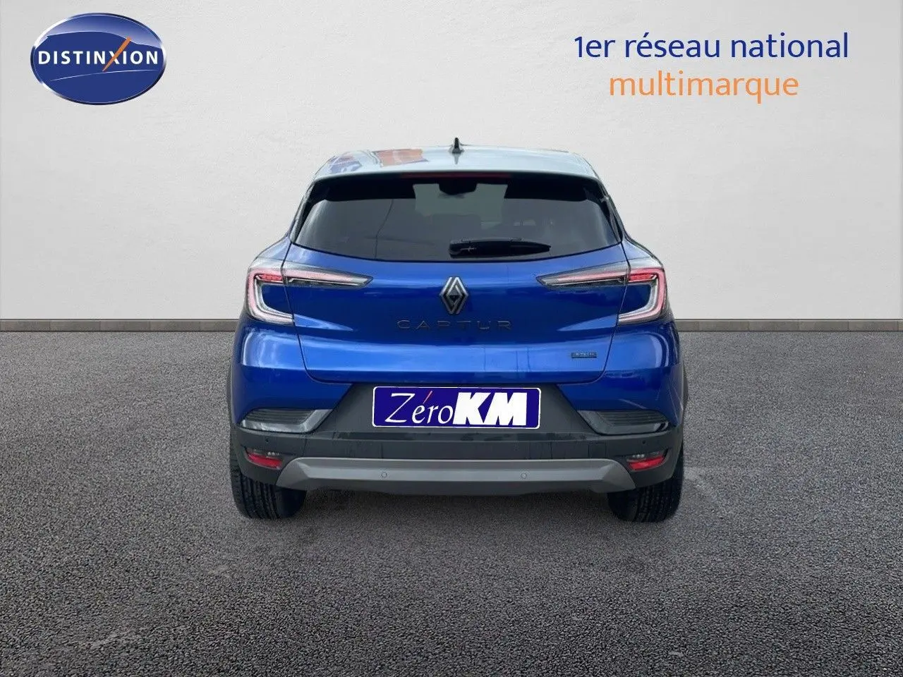 Vue arrière d'un Renault Captur bleu Iron Metal avec toit gris, version hybride E-Tech 2025, sur fond neutre.