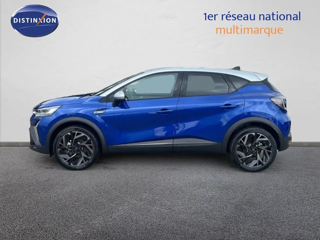 Profil côté gauche du Renault Captur E-Tech hybride 2025 en bleu Iron Metal avec toit gris et jantes noires.