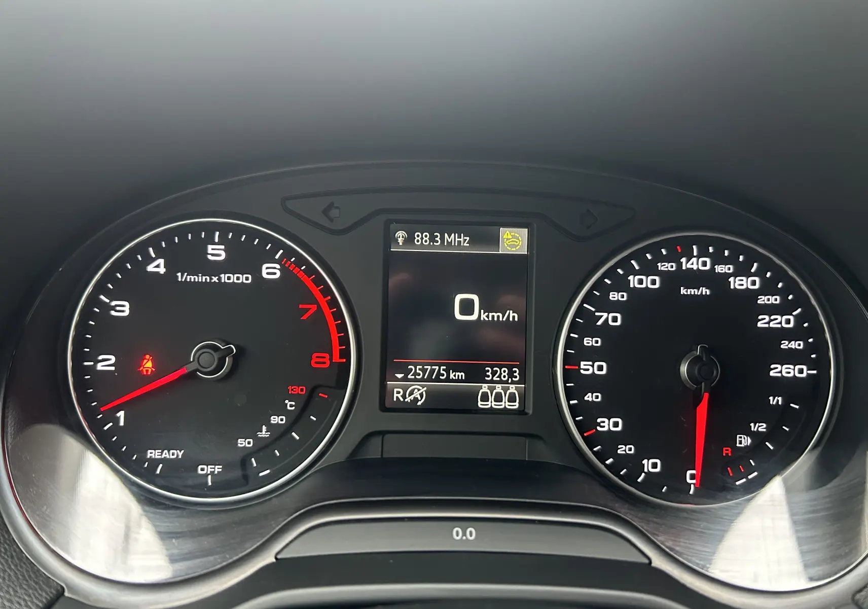 Vue rapprochée du tableau de bord numérique d'un Audi Q2 35 TFSI noir métal, affichant compte-tours, vitesse et écran central.