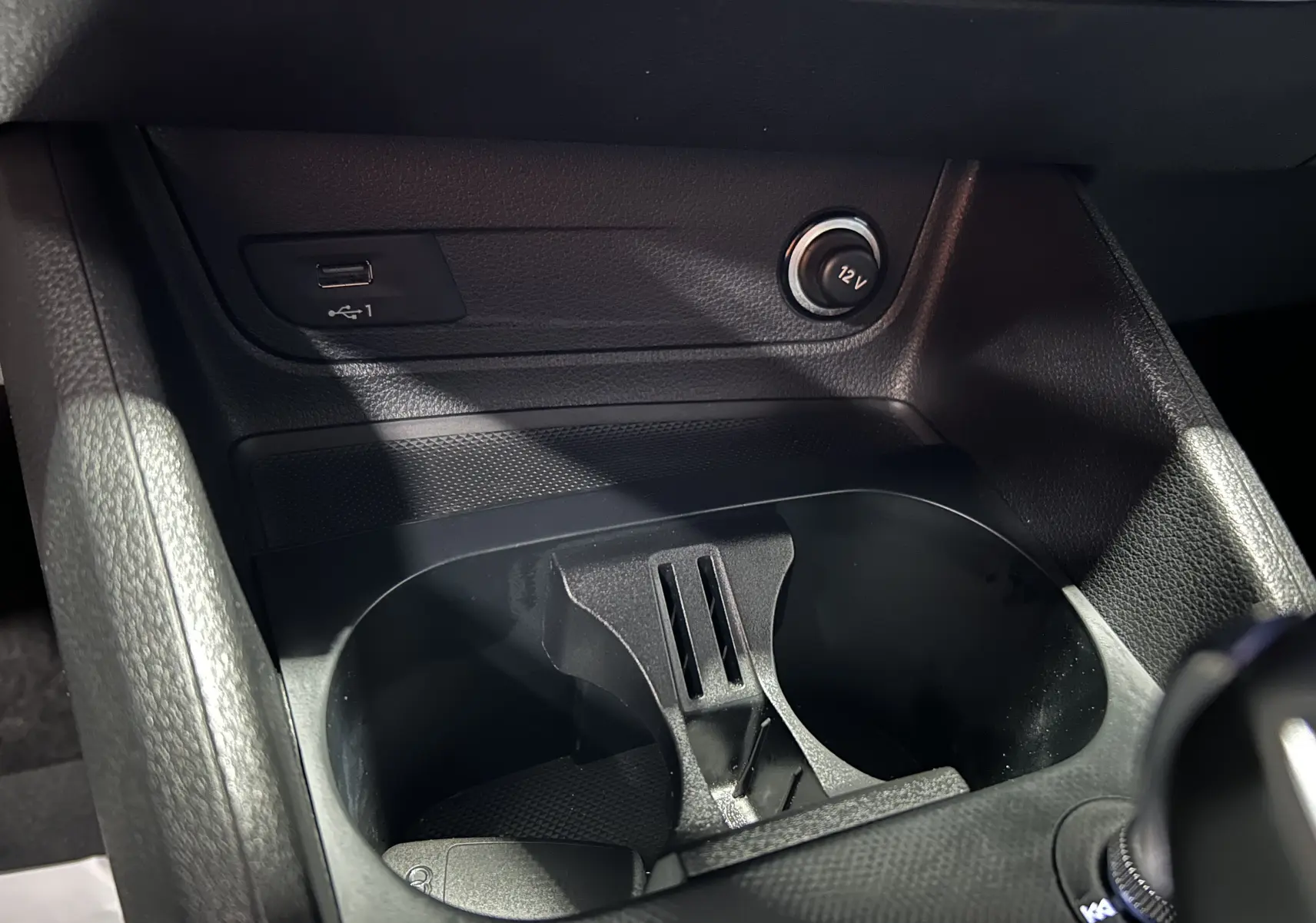 Détail de la console centrale noire du Audi Q2 35 TFSI 150CH S-Line 2023 avec bouton Start/Stop et molette multimédia.