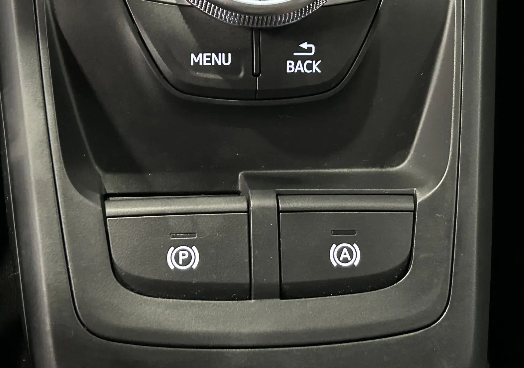 Gros plan sur les commandes audio et navigation au volant d'un Audi Q2 noir métal 2023 finition S-Line.