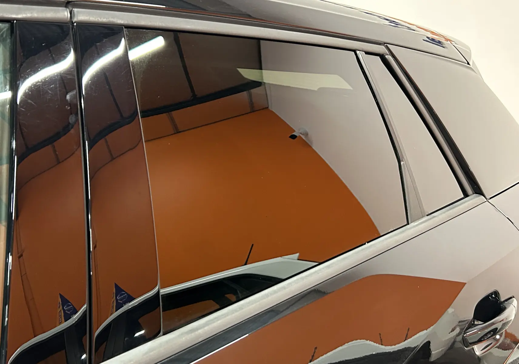 Détail intérieur du tableau de bord avec insert texturé et logo Audi sur un Audi Q2 noir métal 2023.