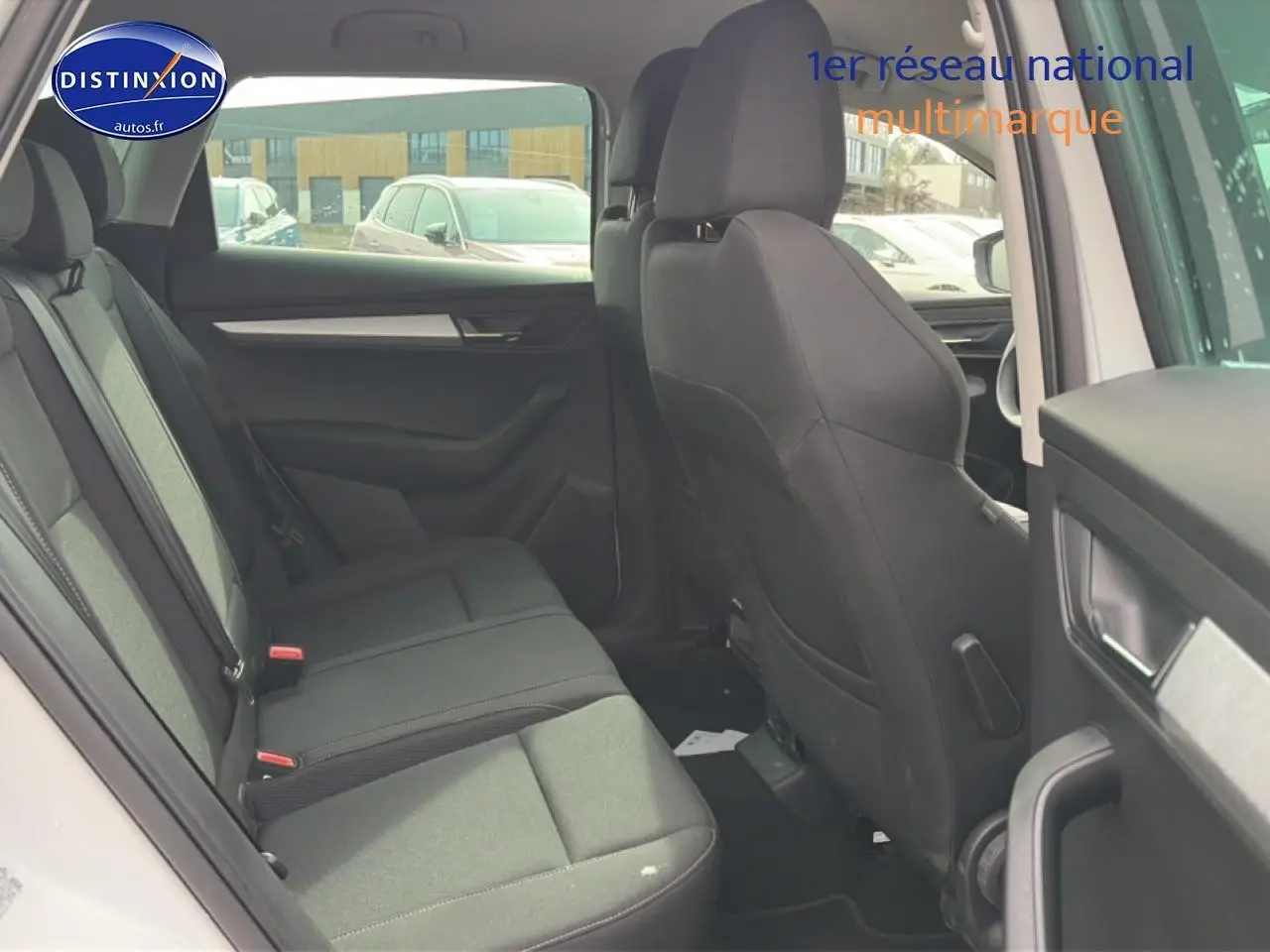 Vue intérieure arrière côté gauche du Skoda Karoq blanc glacial, montrant les sièges et garnitures noires.