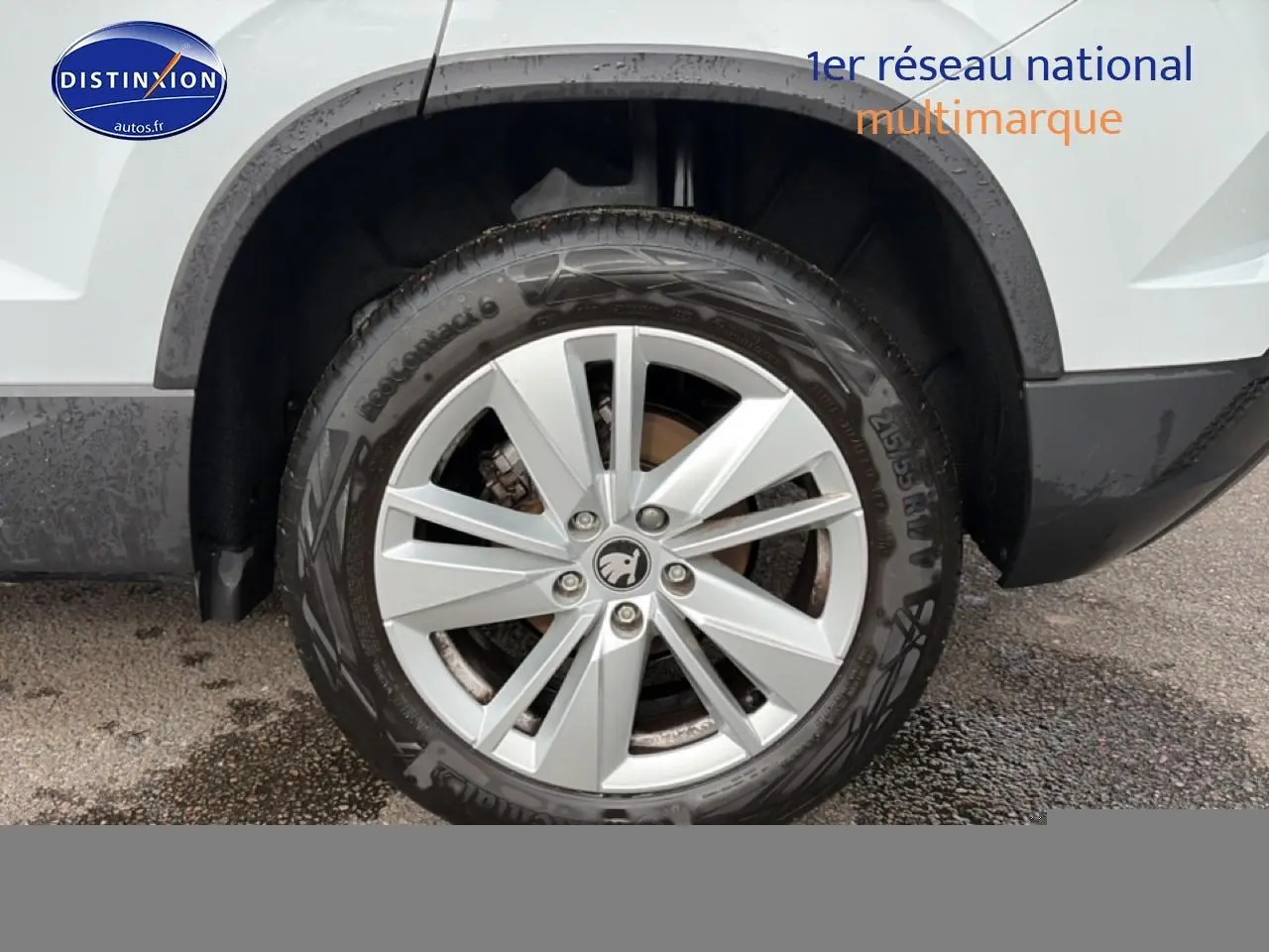 Gros plan sur la roue avant droite d’un Skoda Karoq blanc glacial avec jante alu multibranches.