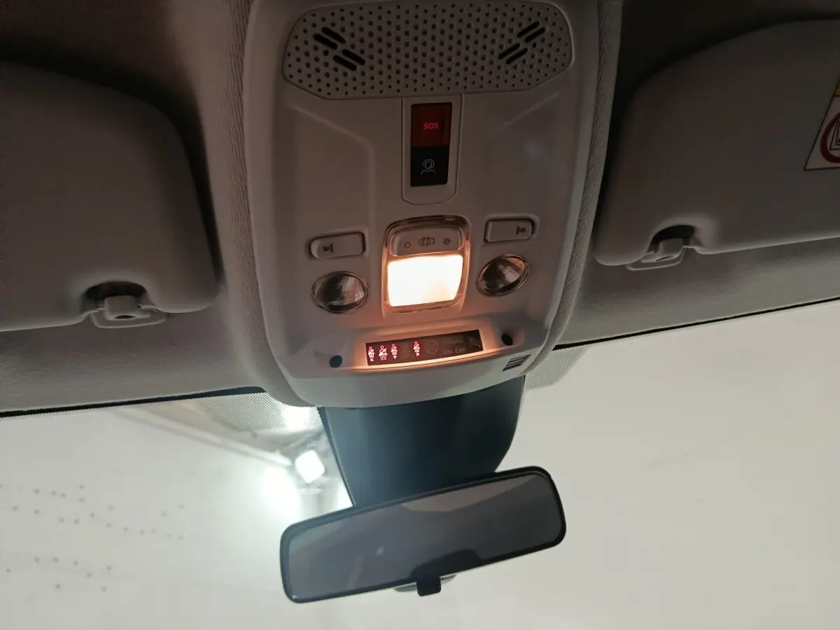 Vue intérieure du plafond avant du Peugeot 208 Hybrid 100 e-DCS6 Style 2025 avec éclairage et boutons SOS activés.
