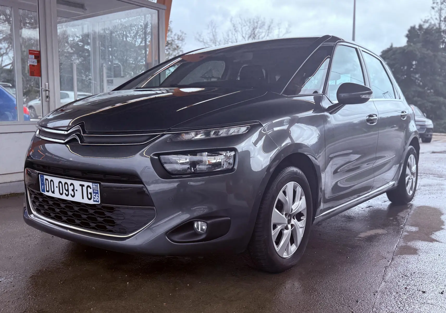 Vue 3/4 avant droit d’une Citroën C4 Picasso gris platinium métal avec calandre distinctive et phares LED.