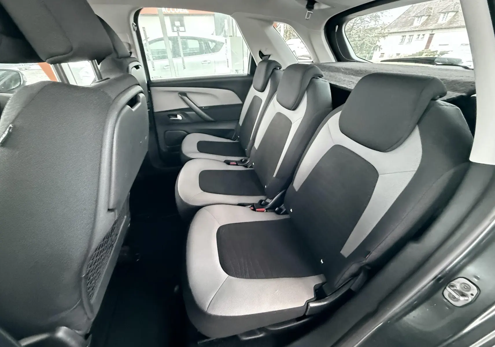Vue intérieure côté droit des sièges arrière en tissu bicolore gris et noir d’une Citroën C4 Picasso 2015.